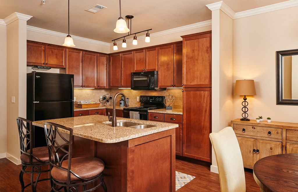 A kitchen with wooden cabinets and a granite countertop.