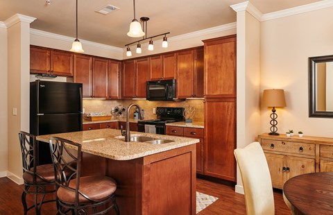 A kitchen with wooden cabinets and a granite countertop.