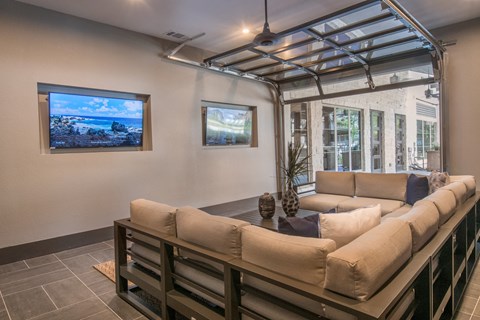A living room with a couch and a television on the wall.