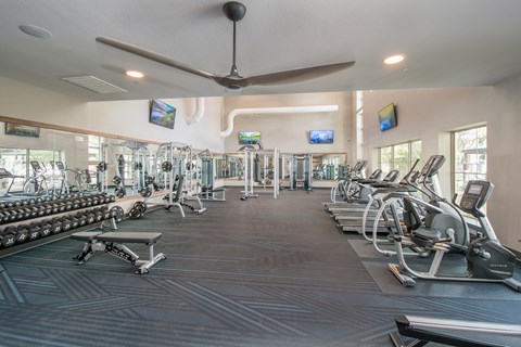A spacious gym with a variety of equipment including treadmills, weights, and exercise machines.