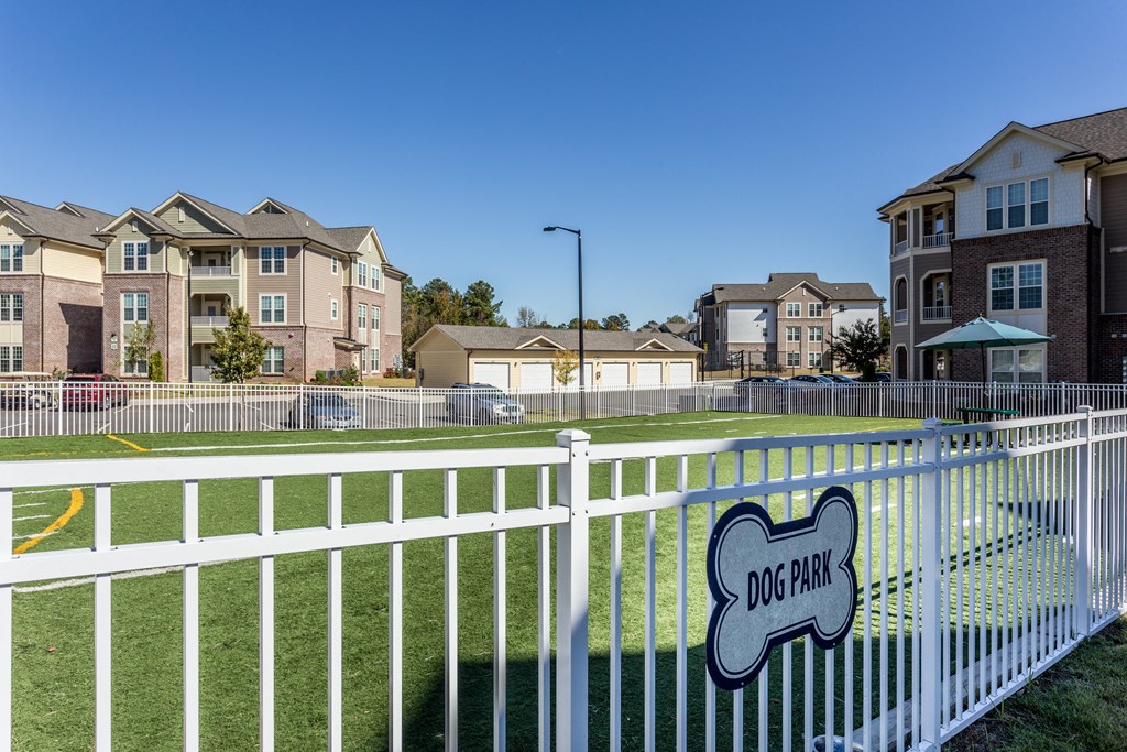 a white fence with a sign on it in front of apartments