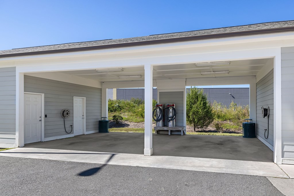 A car garage with two open doors and a car inside.