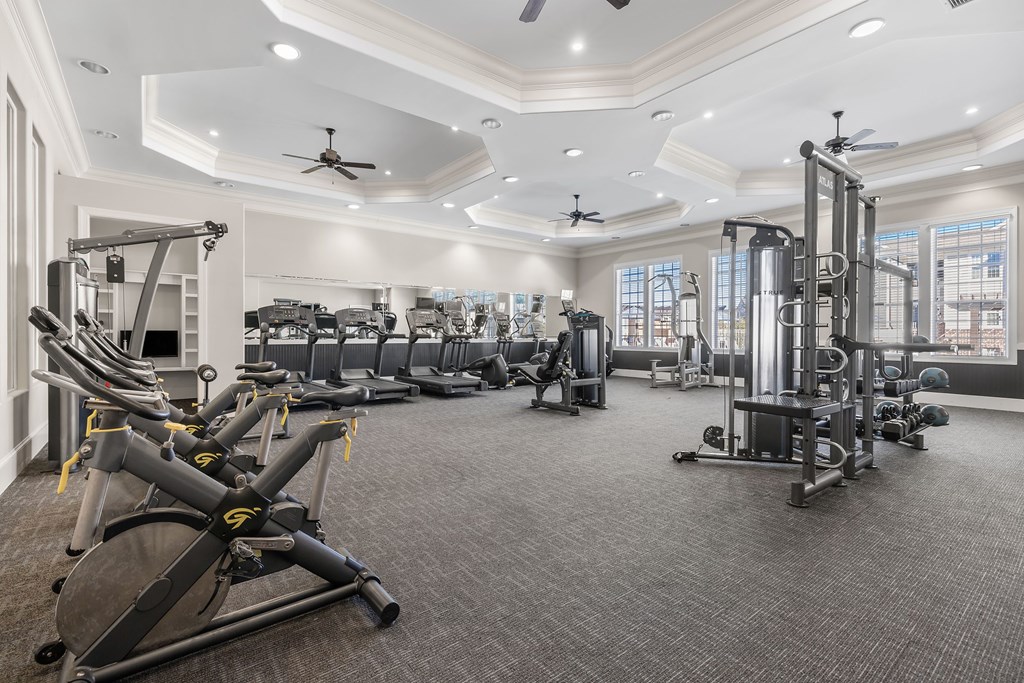A spacious gym with a variety of equipment including treadmills, elliptical machines, and weight machines.