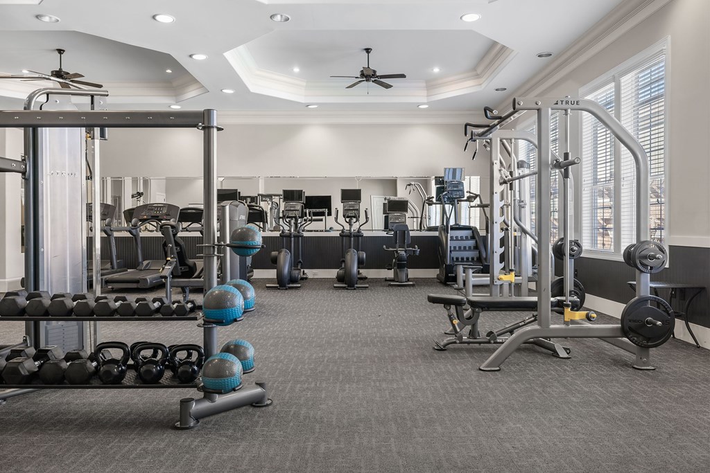A spacious gym with a variety of equipment including weights and machines.