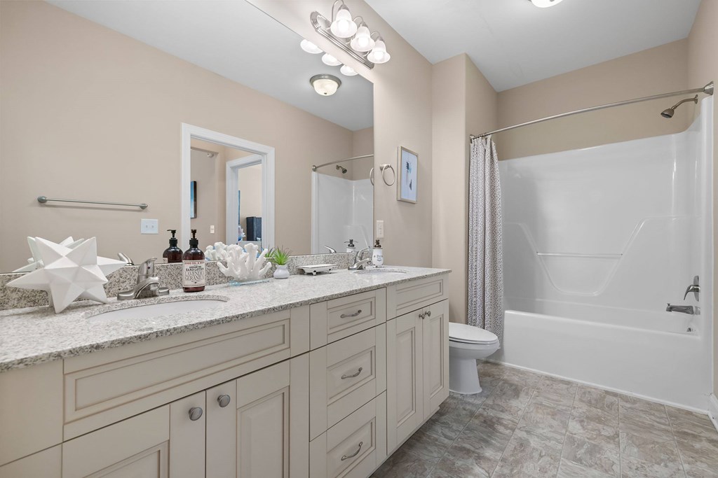A bathroom with a white toilet, sink, and bathtub.