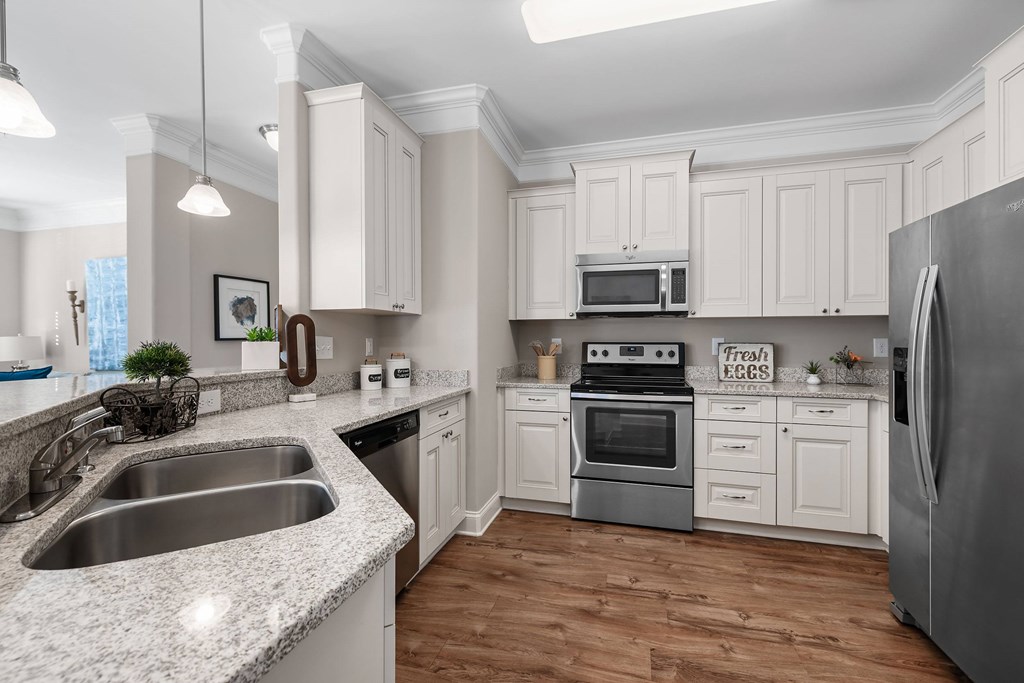 A kitchen with a sink, stove, and refrigerator.