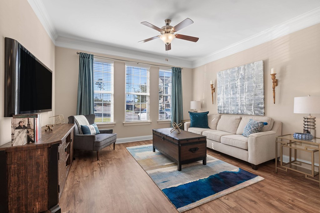A living room with a flat screen TV and a large window.