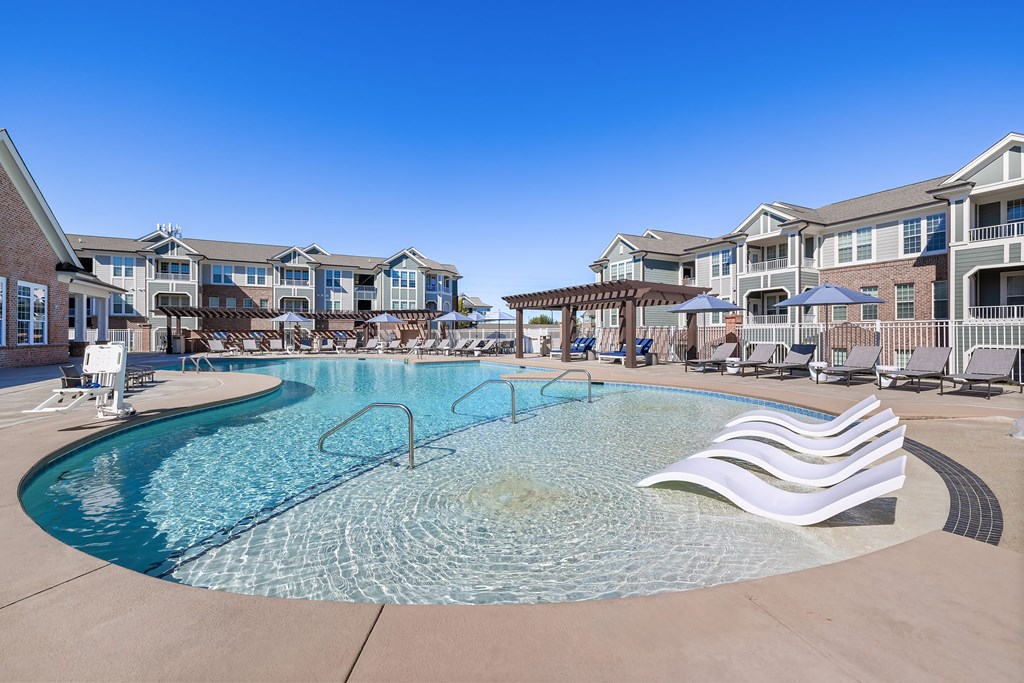 A large swimming pool with a slide and a bench.