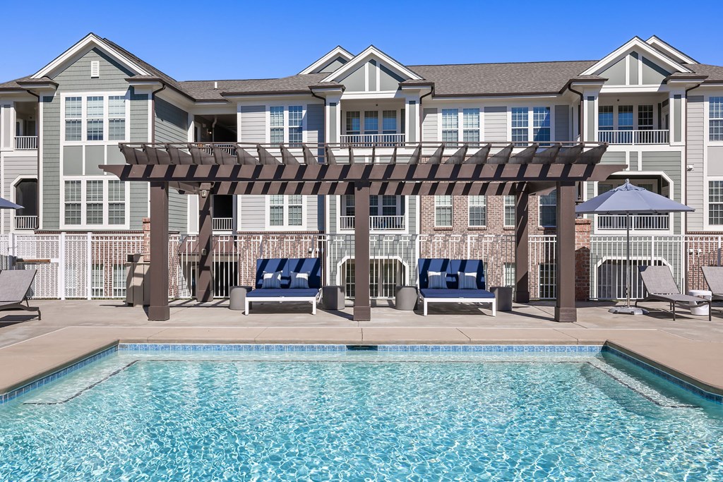 A large building with a pool in front of it.