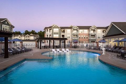 A large swimming pool in front of a resort.