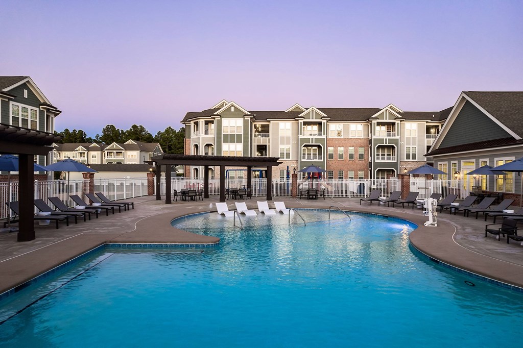 A large swimming pool in front of a resort.