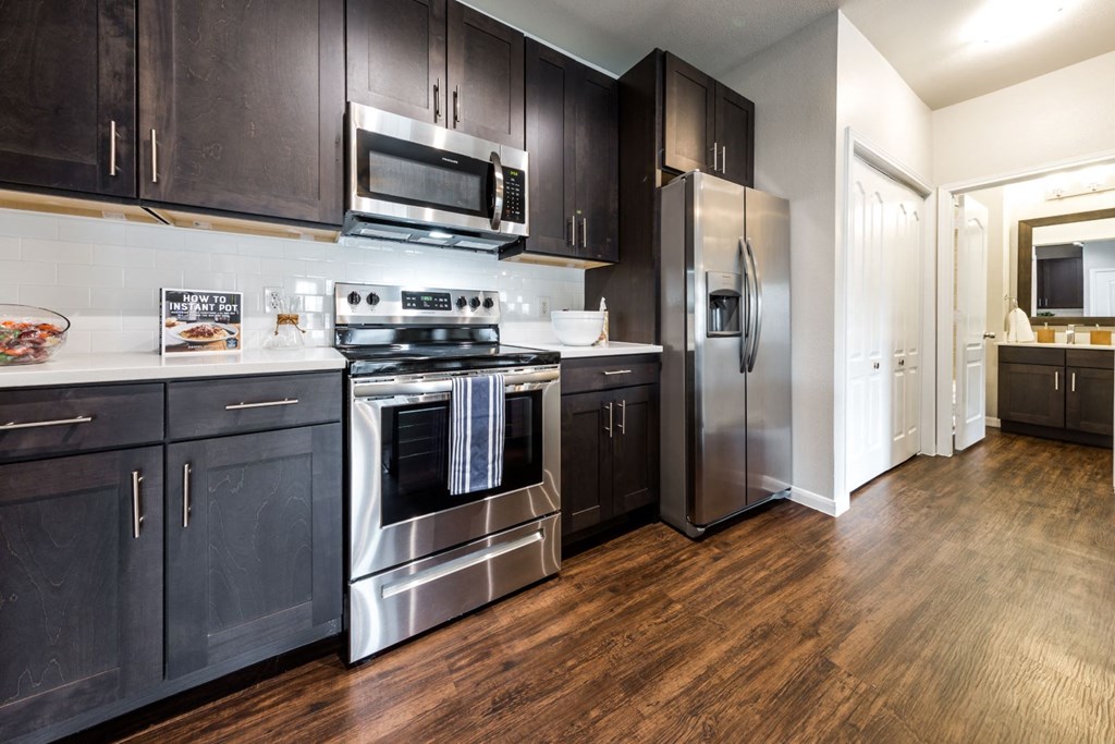 A kitchen with dark wood cabinets and stainless steel appliances.