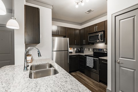 A kitchen with a sink and a refrigerator.