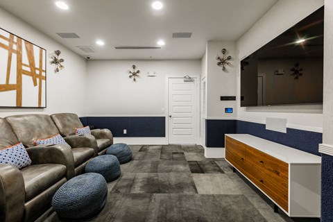A living room with brown leather couches and a blue and white accent wall.