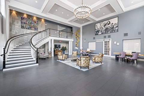 a large lobby with a staircase and a living room with furniture