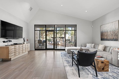 A modern living room with a black chair and a large painting on the wall.