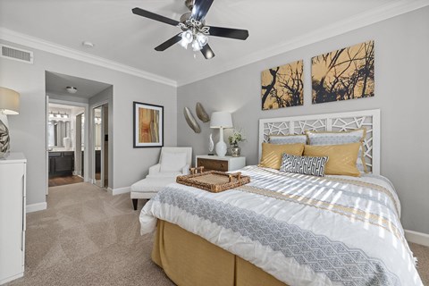 A bedroom with a large bed and a ceiling fan.