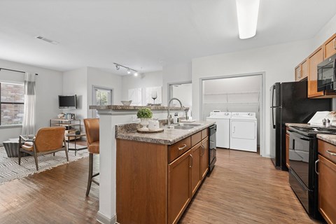 A modern kitchen with wooden cabinets and black appliances.