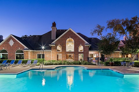 A large house with a pool in front.