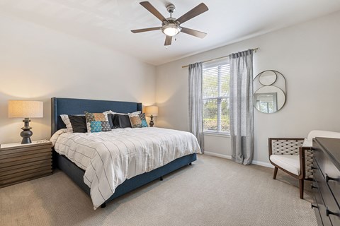 A bedroom with a large bed and a ceiling fan.