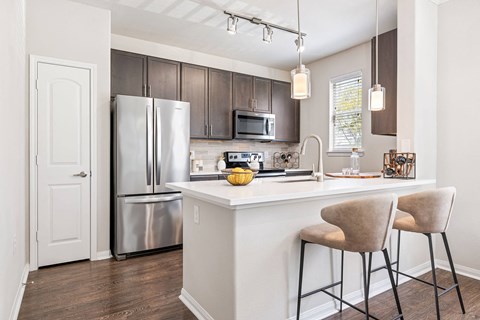 A kitchen with a white counter and a refrigerator.