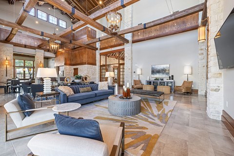A large, open-concept living room with a high ceiling and exposed beams.