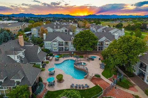 A sunset view of a residential area with a swimming pool.