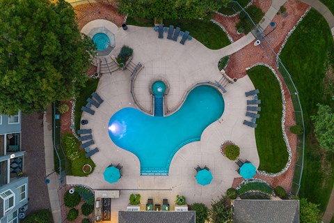 A large outdoor swimming pool surrounded by a brick border.