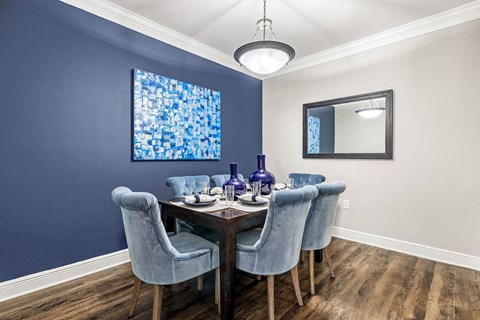 A dining room with a wooden table and blue chairs.