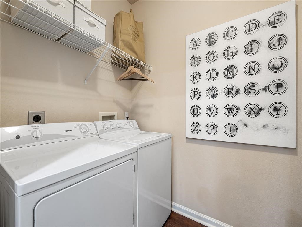 a white washer and dryer in a laundry room with a wall art