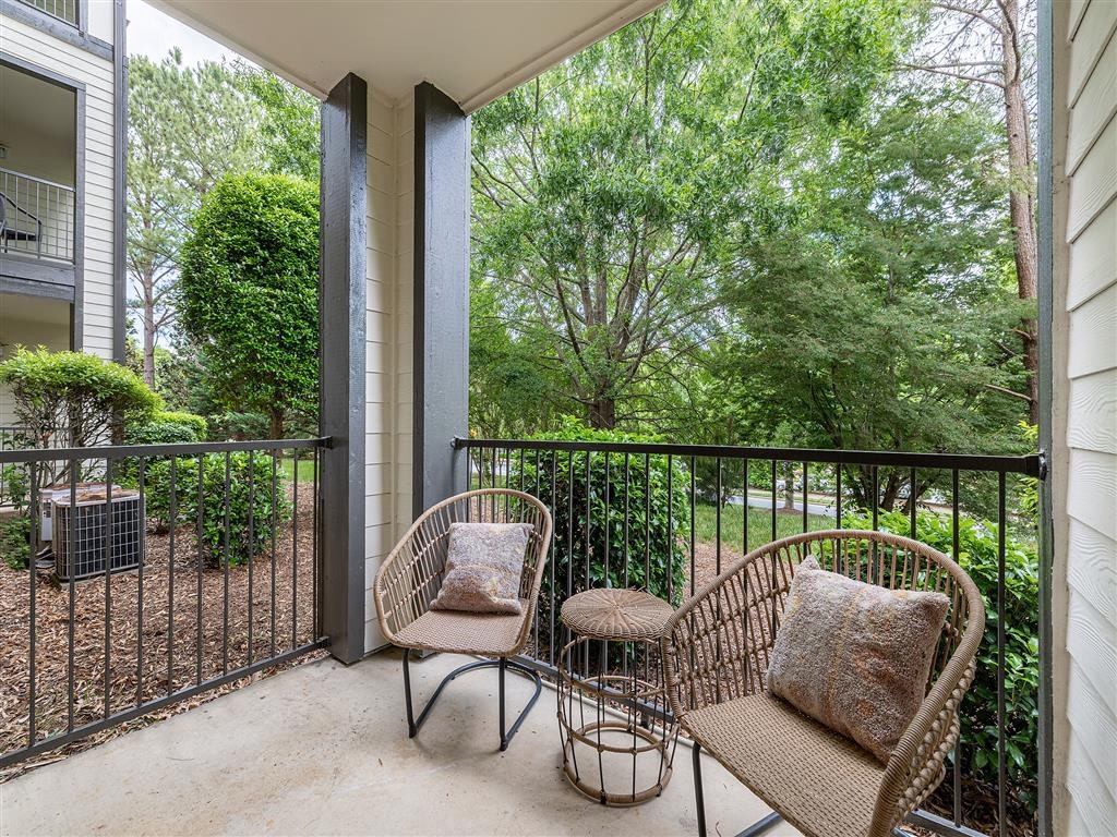 a patio with two chairs and a table on a balcony