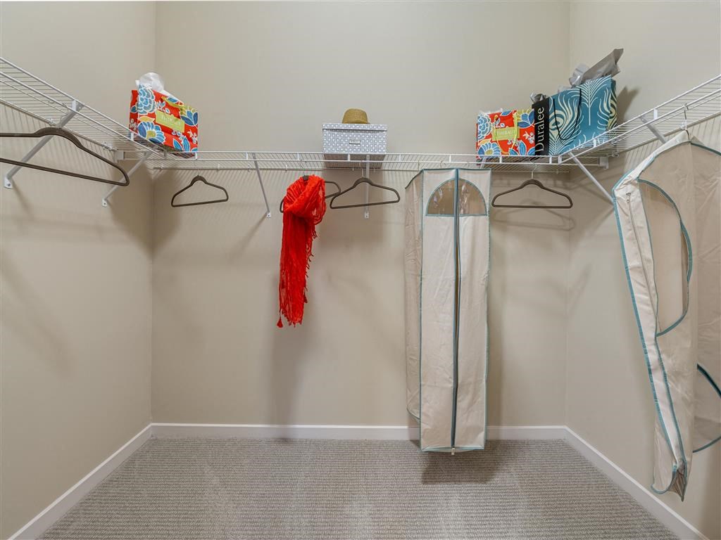 a closet with clothes and towels and racks