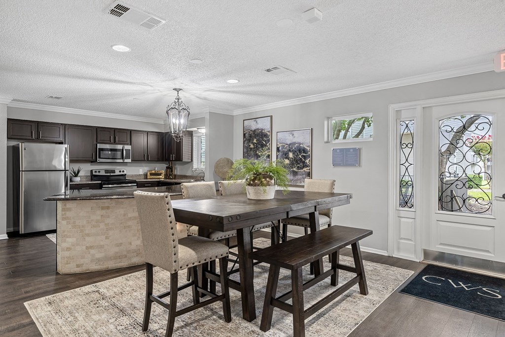 a kitchen with a large island and a table with chairs