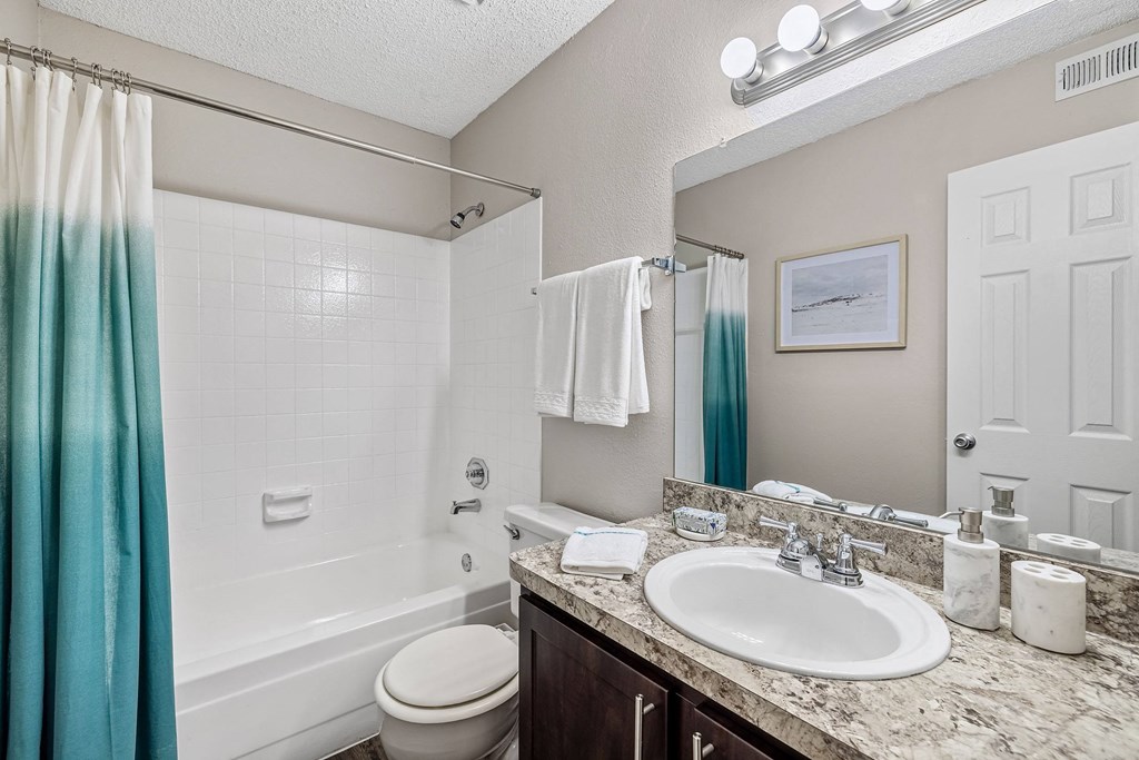 a bathroom with a white tub and a sink and a mirror