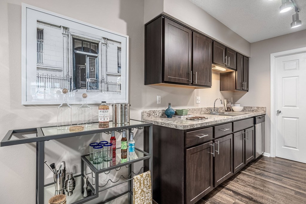 a kitchen with dark wood cabinets and a counter with a glass counter top