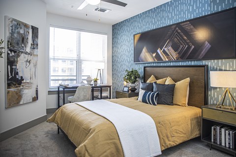 A bedroom with a large bed and a painting on the wall.