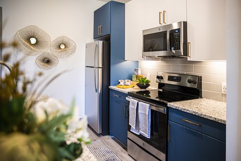 A kitchen with a blue refrigerator and a black stove top oven.