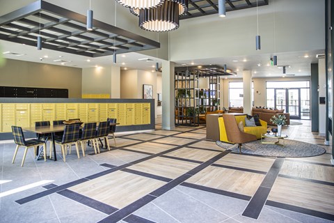 A large open space with a dining area and a yellow sofa.