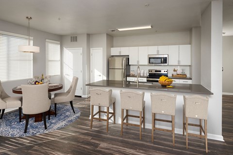 an open kitchen and dining room with a large island and chairs