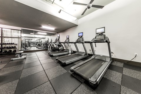 A gym with treadmills and elliptical machines.