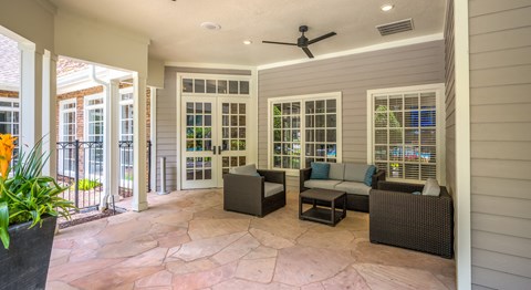 A patio with a ceiling fan and furniture.