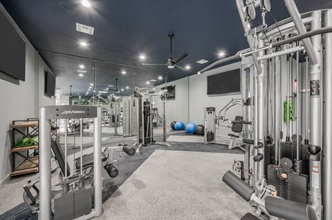 A well-equipped gym with a variety of machines and weights.