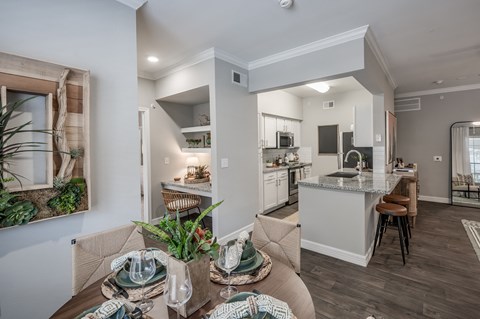 A modern kitchen and dining area with a table set for a meal.