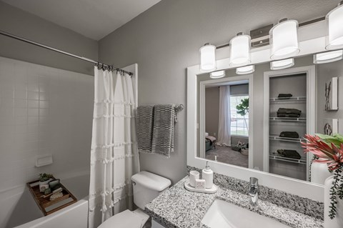 A bathroom with a white toilet, sink, and shower curtain.