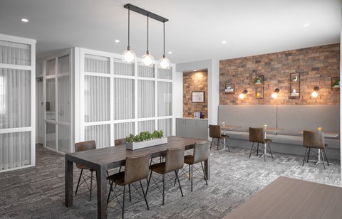 A modern dining room with a long table and chairs.