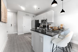 a kitchen with white cabinets and a counter top in a living room