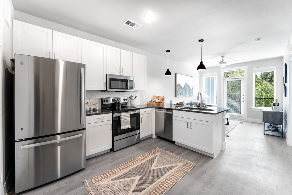 a kitchen with stainless steel appliances and white cabinets