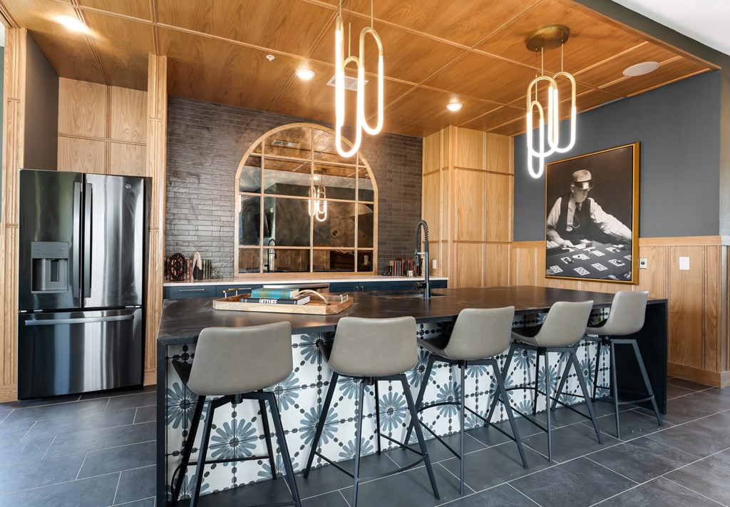 a kitchen with a large island and a stainless steel refrigerator