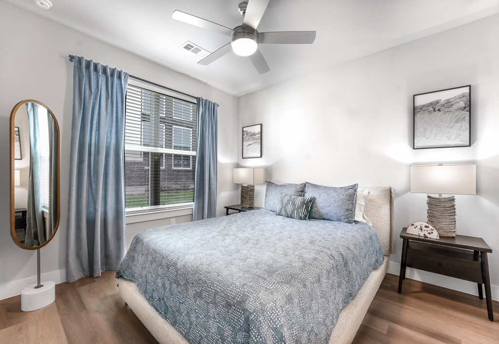 large bedroom with queen size bedroom and natural lighting with bedside table