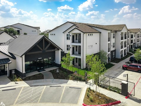 an aerial view of an apartment complex with cars parked in a parking lot